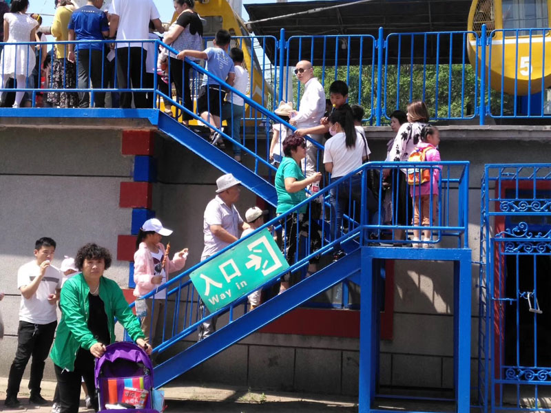 每年六一，陽陽（二樓緩步臺背書包女孩）都能在公園玩?zhèn)€痛快