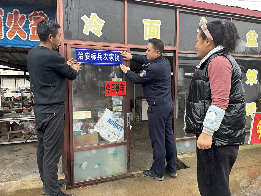 農(nóng)家院老板管立法（左）將“治安標(biāo)兵農(nóng)家院”牌匾掛在最顯眼的位置