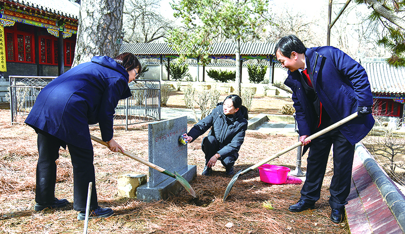 庭長(zhǎng)賈宏斌（右一）、副庭長(zhǎng)史致鶴（左一）、法官助理李元旬為古樹(shù)填土澆水